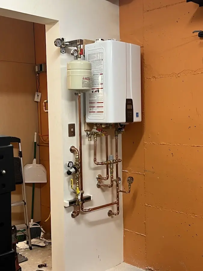 Plumbing technician inspecting water heater connections in Galt